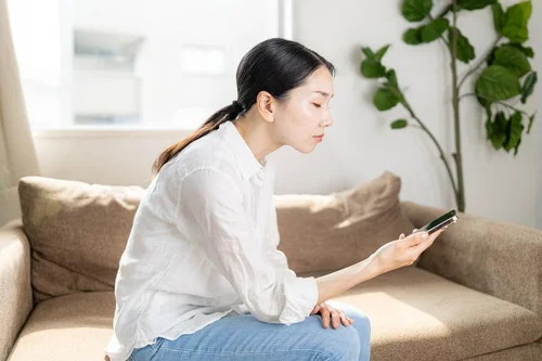 姿勢が悪いままスマホを操作する女性