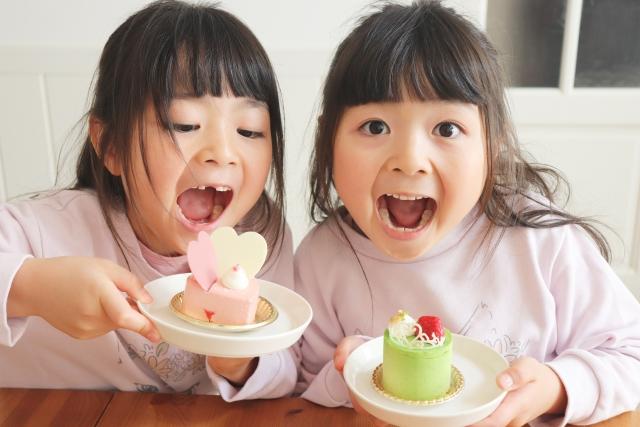 甘いおやつを食べる2人の女の子